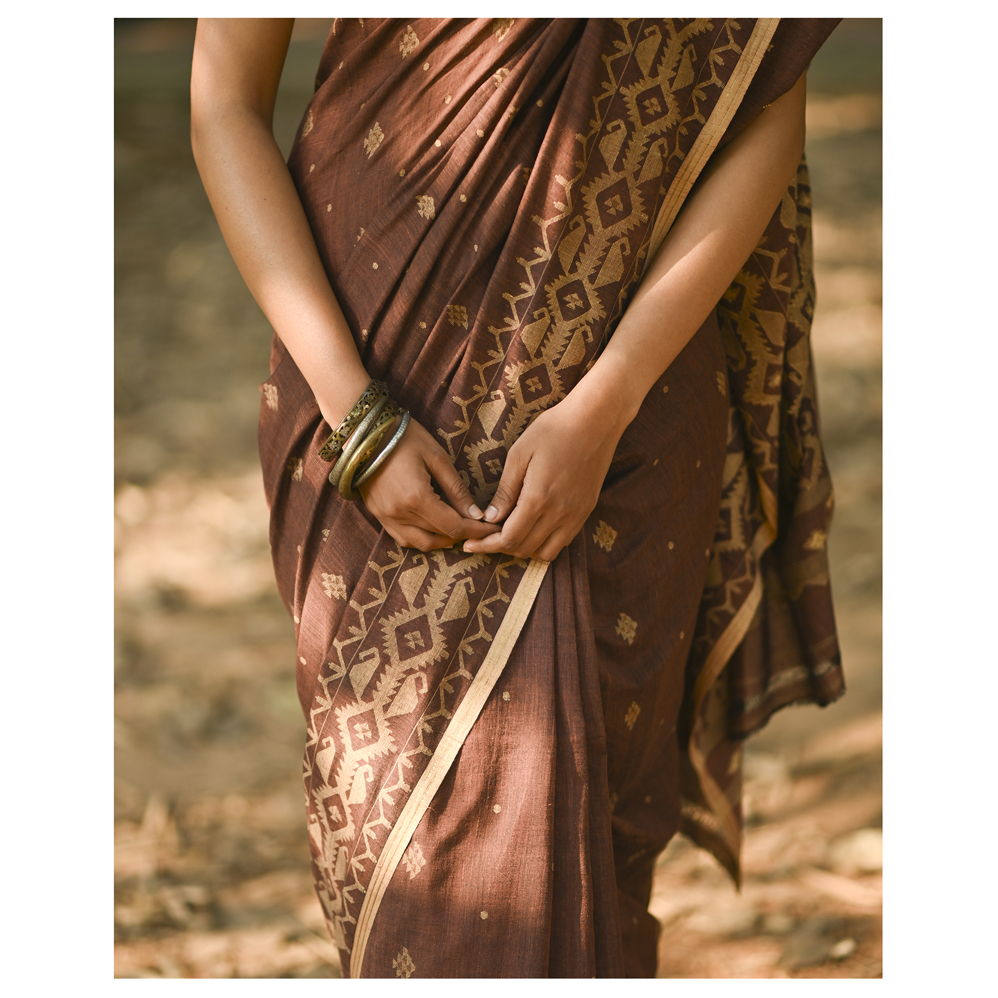 Model wearing the Cocoa Geometry Jamdani Saree, a handwoven deep cocoa brown with sand-beige weave Jamdani saree with geometric body motifs with woven butis and richly worked pallu with bold geometric detailing.
