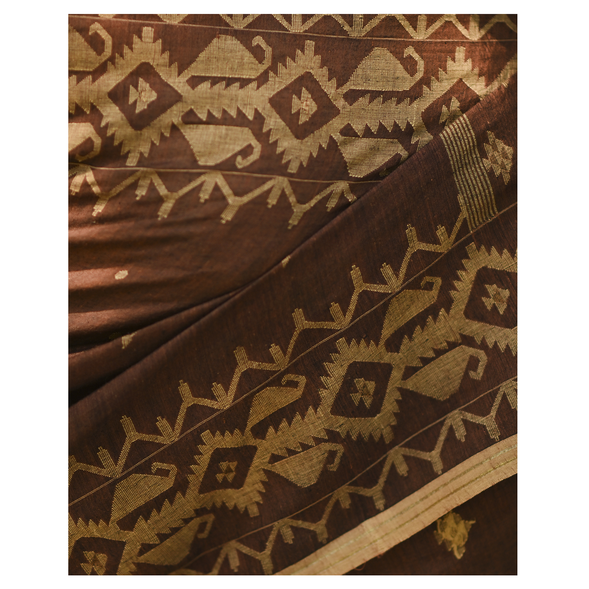 Model wearing the Cocoa Geometry Jamdani Saree, a handwoven deep cocoa brown with sand-beige weave Jamdani saree with geometric body motifs with woven butis and richly worked pallu with bold geometric detailing.