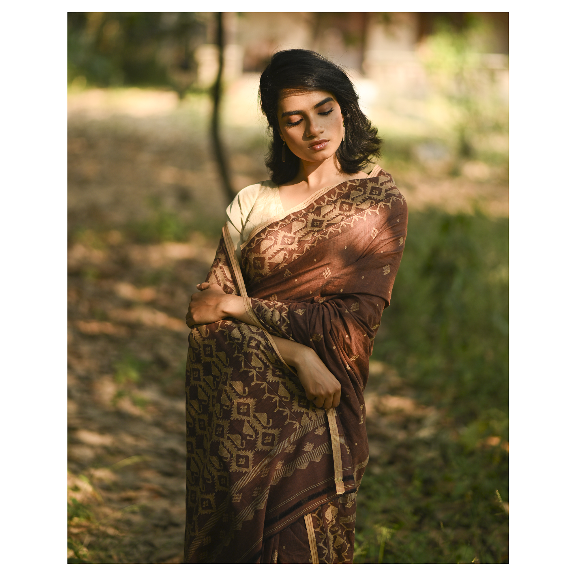 Model wearing the Cocoa Geometry Jamdani Saree, a handwoven deep cocoa brown with sand-beige weave Jamdani saree with geometric body motifs with woven butis and richly worked pallu with bold geometric detailing.
