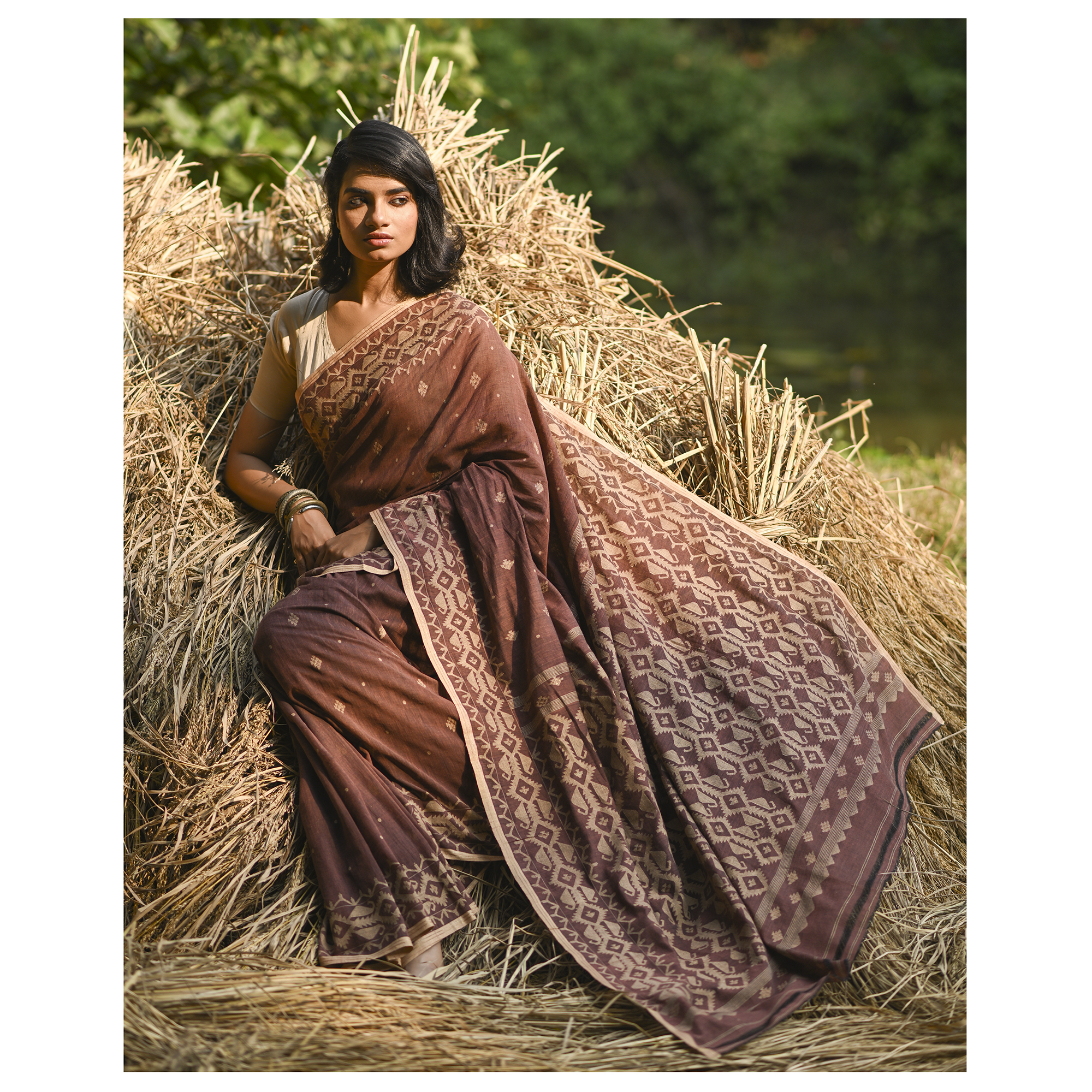 Model wearing the Cocoa Geometry Jamdani Saree, a handwoven deep cocoa brown with sand-beige weave Jamdani saree with geometric body motifs with woven butis and richly worked pallu with bold geometric detailing.