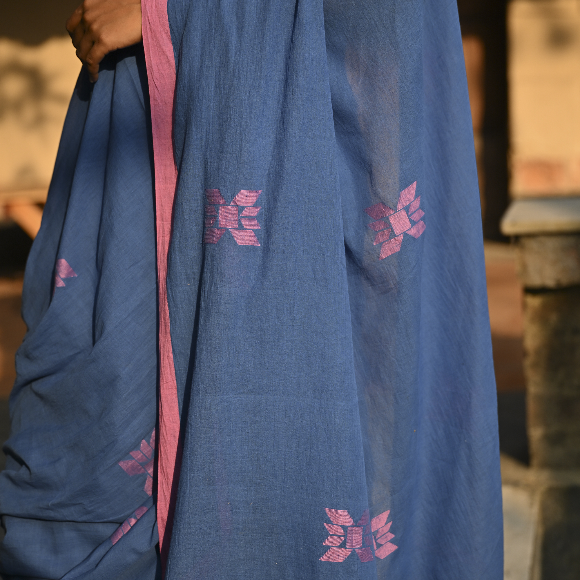 Model wearing the Indigo Blush Jamdani Saree, a handwoven moody indigo with blush-pink accents Jamdani saree with subtle woven motifs highlighted with blush contrast and border-led pallu with restrained pink detailing.