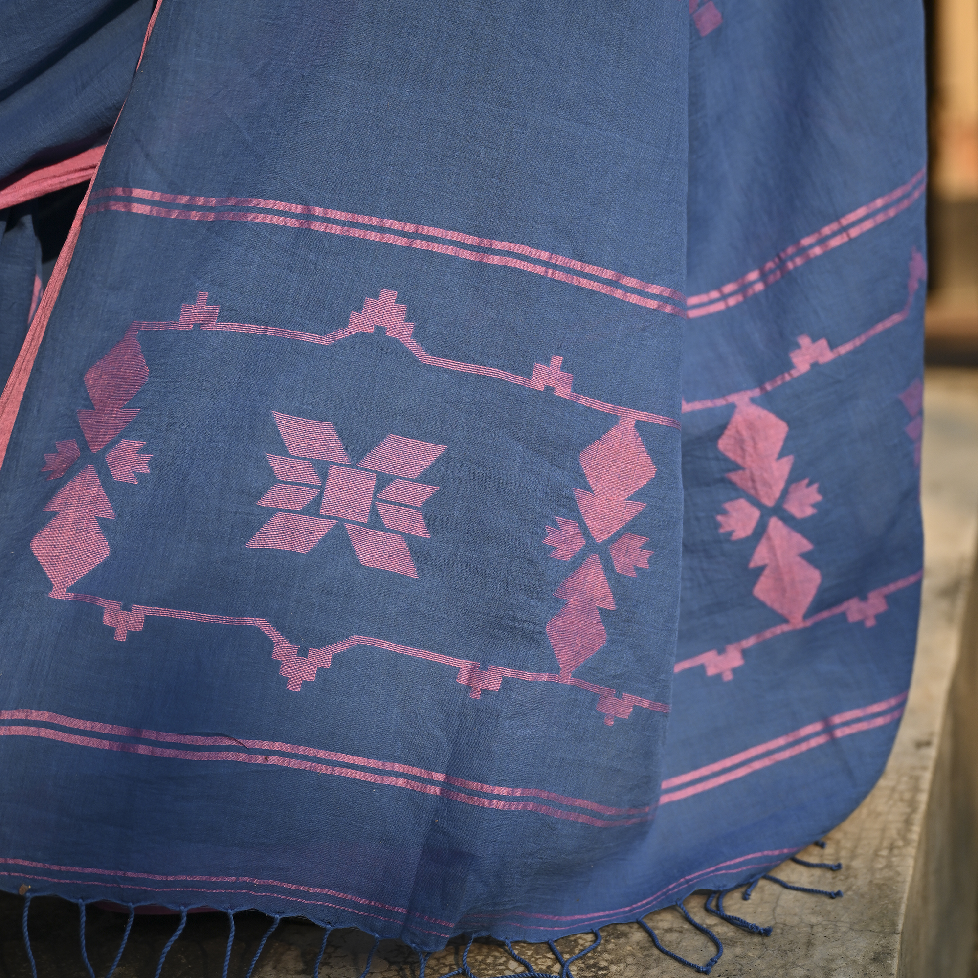 Model wearing the Indigo Blush Jamdani Saree, a handwoven moody indigo with blush-pink accents Jamdani saree with subtle woven motifs highlighted with blush contrast and border-led pallu with restrained pink detailing.