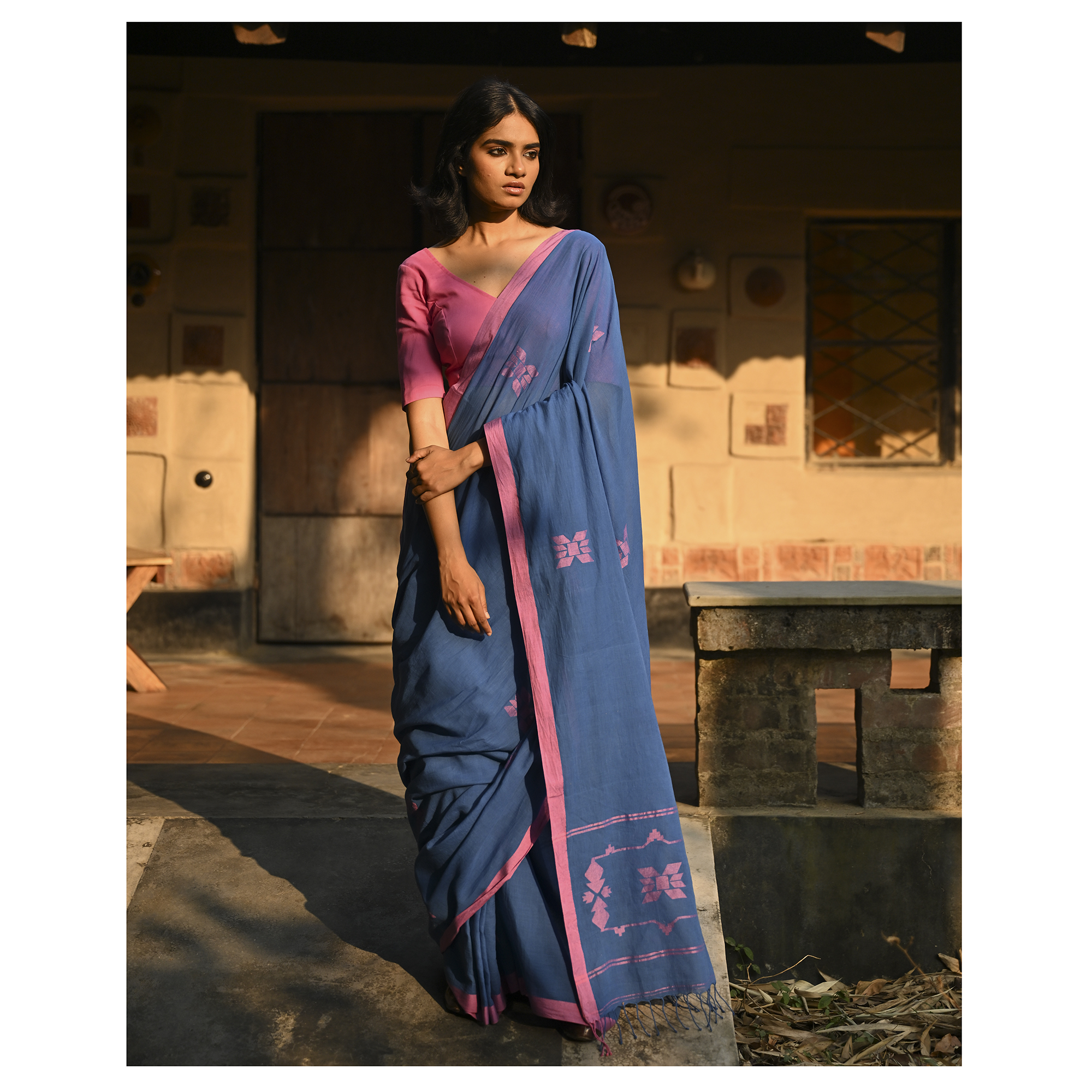 Model wearing the Indigo Blush Jamdani Saree, a handwoven moody indigo with blush-pink accents Jamdani saree with subtle woven motifs highlighted with blush contrast and border-led pallu with restrained pink detailing.