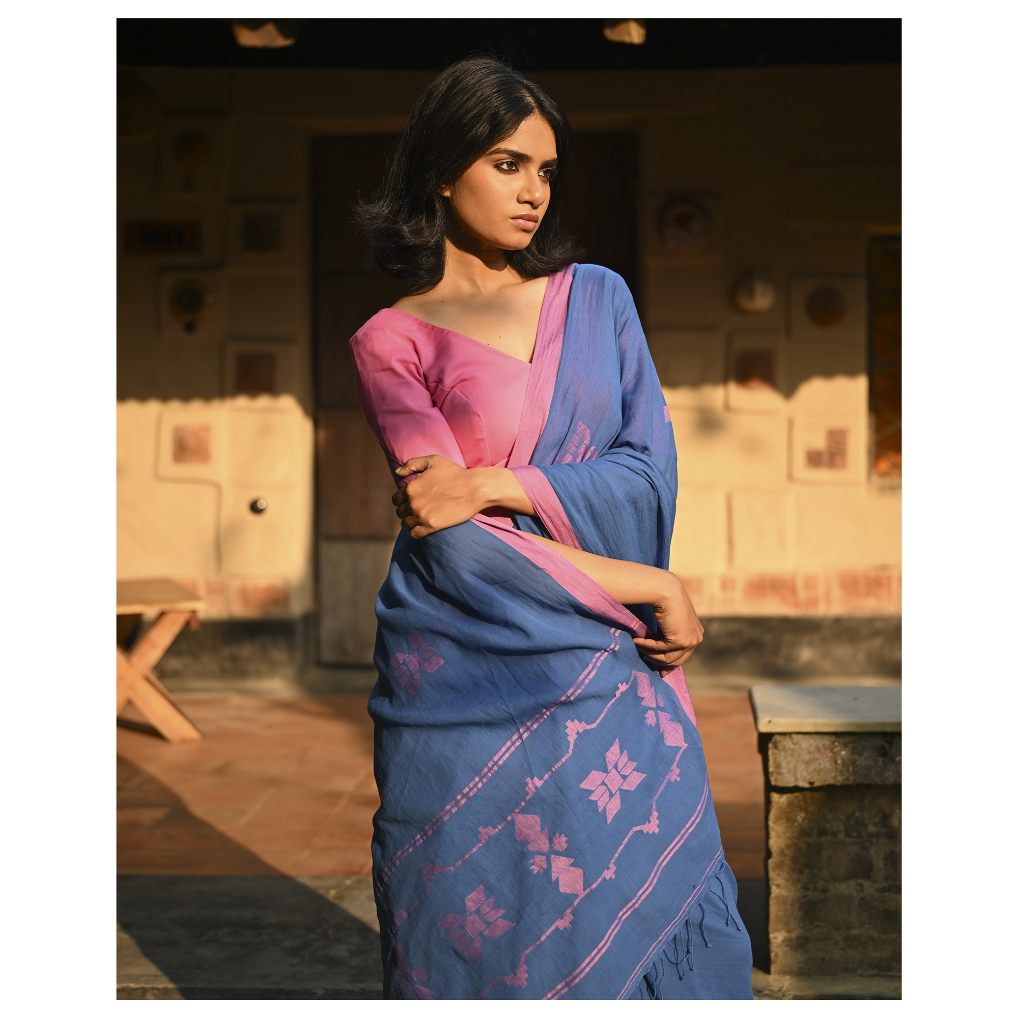 Model wearing the Indigo Blush Jamdani Saree, a handwoven moody indigo with blush-pink accents Jamdani saree with subtle woven motifs highlighted with blush contrast and border-led pallu with restrained pink detailing.