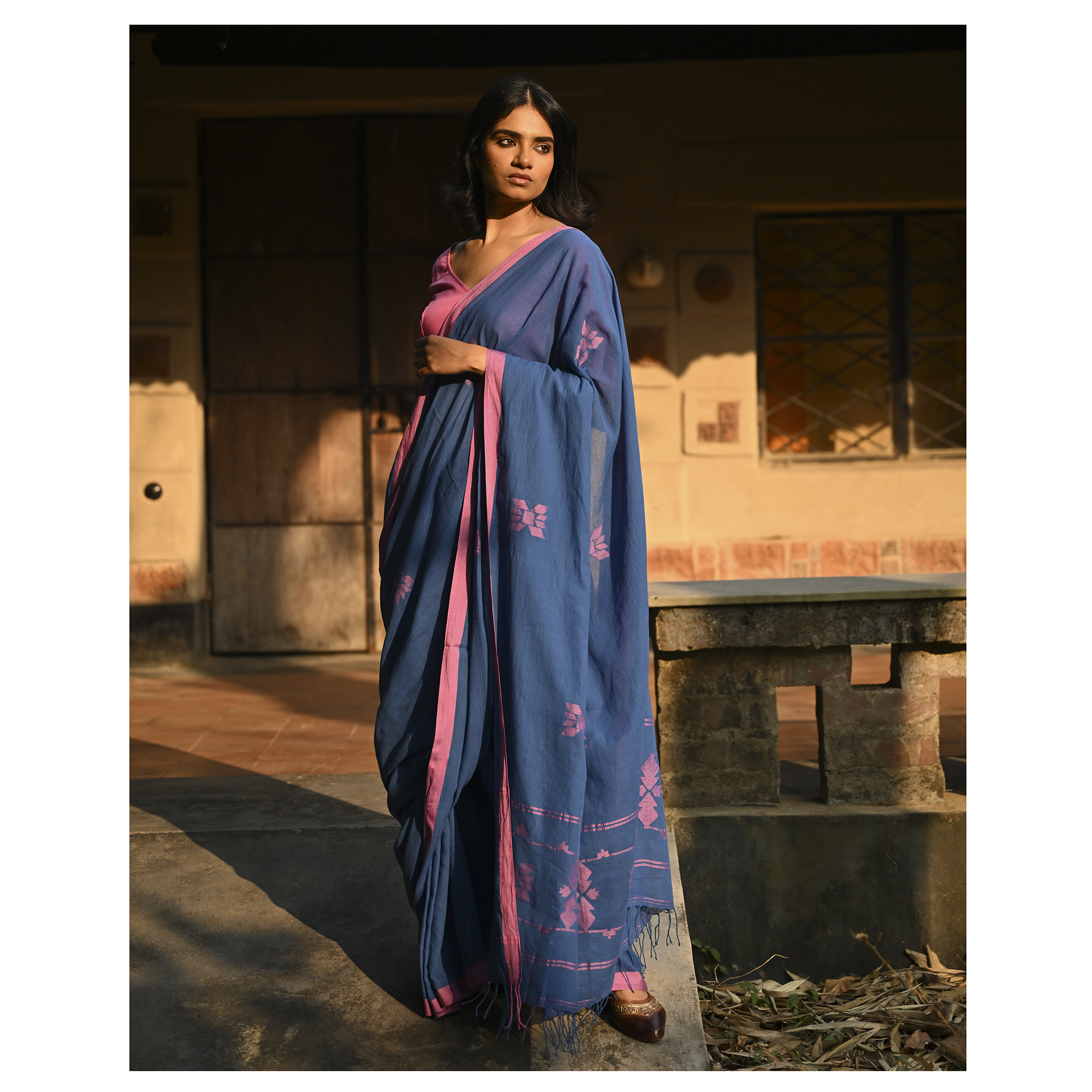 Model wearing the Indigo Blush Jamdani Saree, a handwoven moody indigo with blush-pink accents Jamdani saree with subtle woven motifs highlighted with blush contrast and border-led pallu with restrained pink detailing.