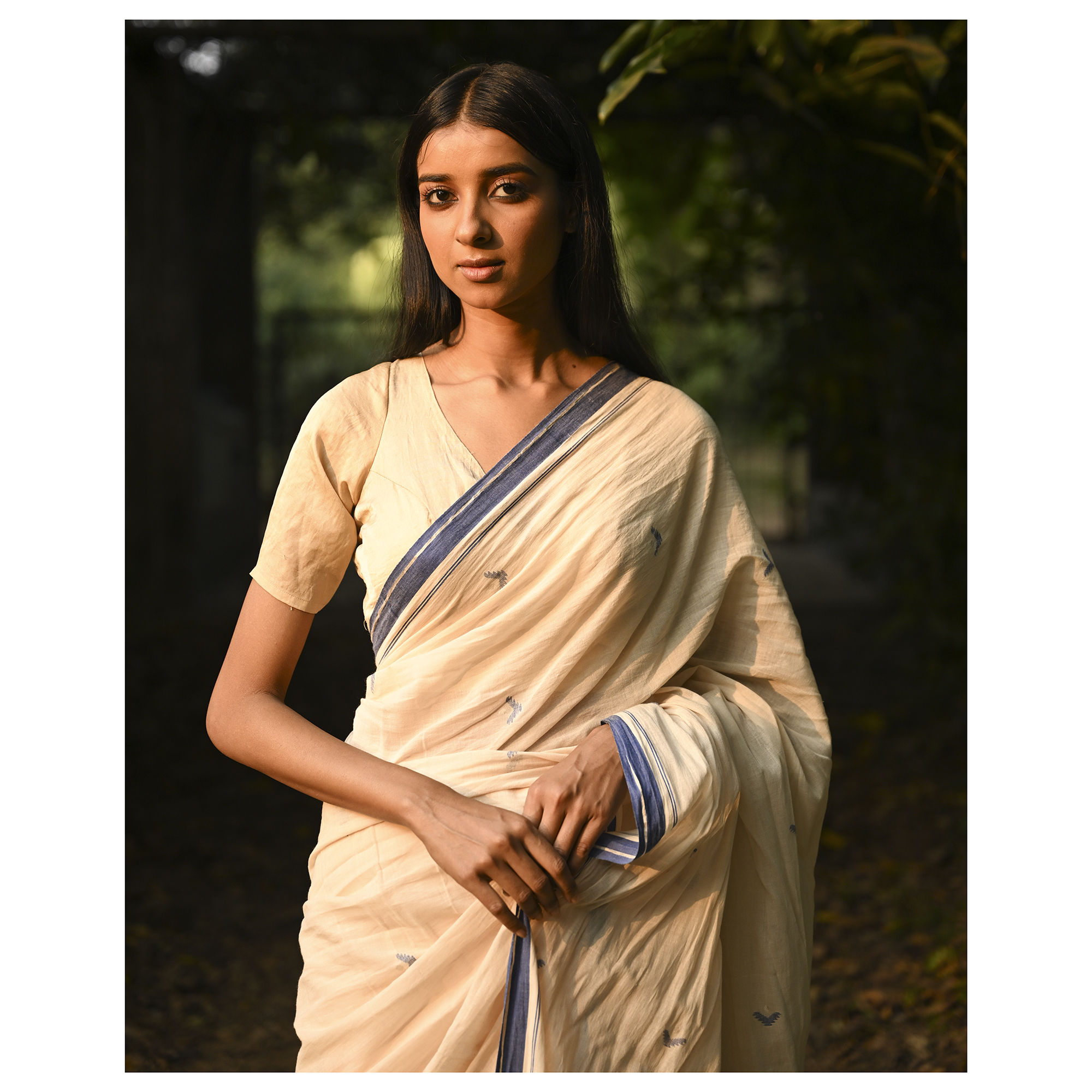 Model wearing the Ivory Blue-Border Jamdani Saree, a handwoven soft ivory with muted blue border accents Jamdani saree with minimal woven accents with quiet buti work and clean pallu framed by a restrained blue border.