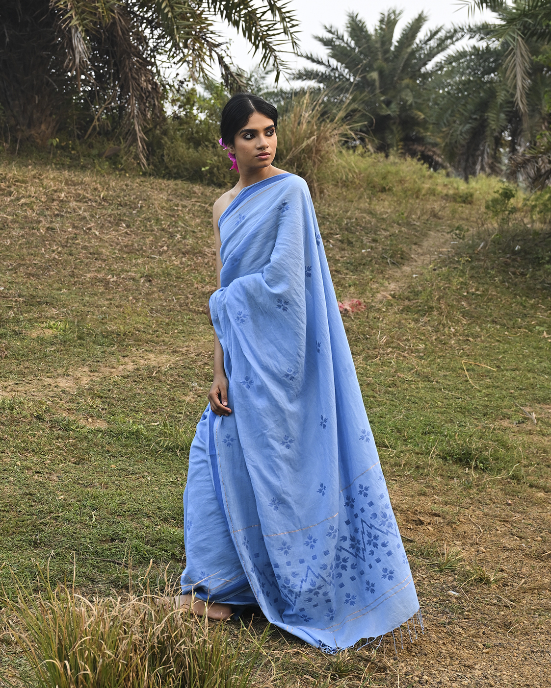 Model wearing the Powder Blue Floral Buti Jamdani Saree, a handwoven powder blue with tonal floral butis Jamdani saree with tonal floral butis scattered across the body and minimal pallu with a clean tonal finish.
