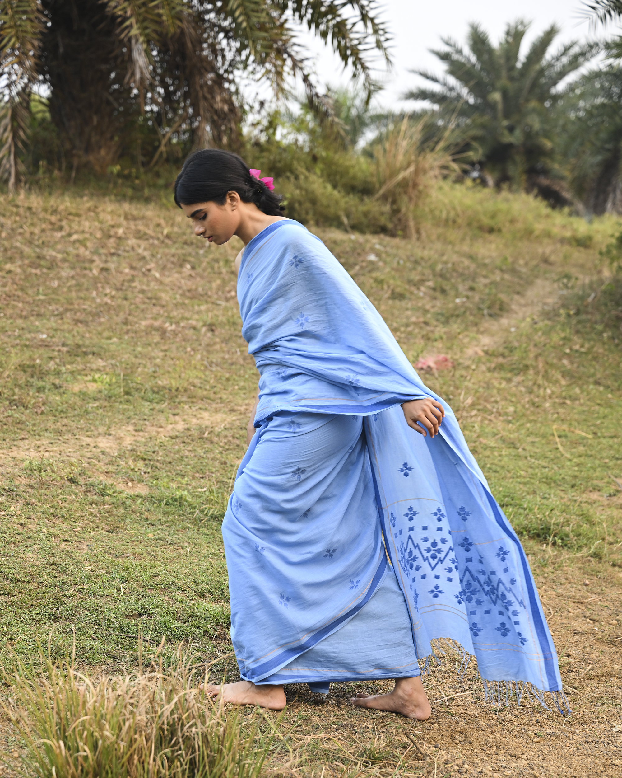 Model wearing the Powder Blue Floral Buti Jamdani Saree, a handwoven powder blue with tonal floral butis Jamdani saree with tonal floral butis scattered across the body and minimal pallu with a clean tonal finish.