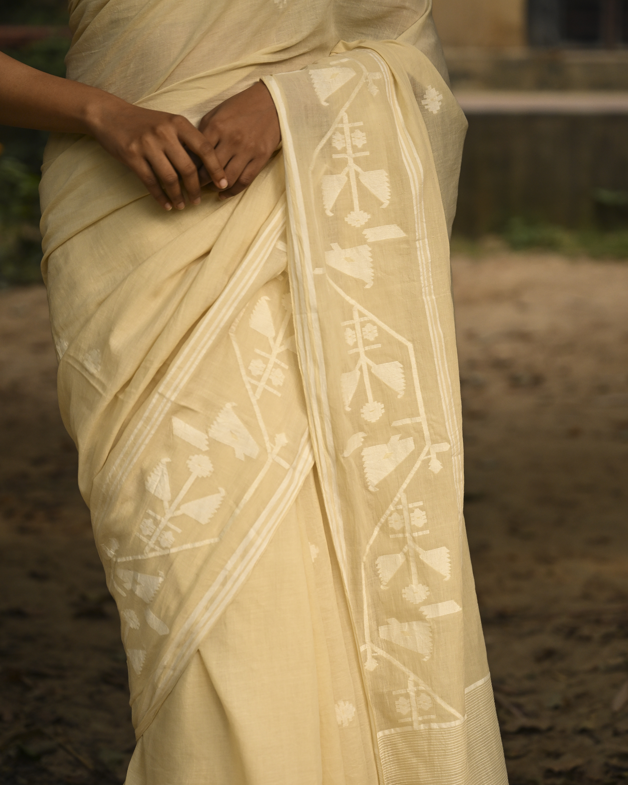 Model wearing the Buttercream Tone-on-Tone Jamdani Saree, a handwoven buttercream with tone-on-tone weaving Jamdani saree with quiet woven motifs in a soft monochrome language and whisper-light pallu with subtle border luminosity.