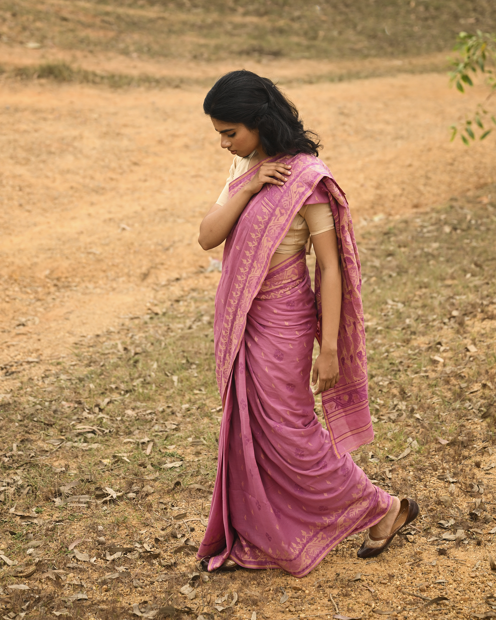 Model wearing the Mauve Gold-Detail Jamdani Saree, a handwoven muted mauve with soft gold detailing Jamdani saree with gentle woven motifs with a graceful festive border and elegant pallu with understated gold-rich work.