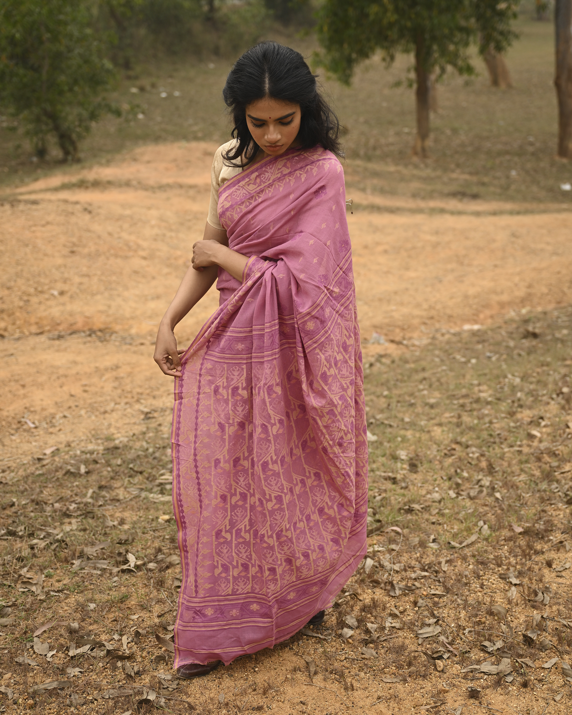 Model wearing the Mauve Gold-Detail Jamdani Saree, a handwoven muted mauve with soft gold detailing Jamdani saree with gentle woven motifs with a graceful festive border and elegant pallu with understated gold-rich work.