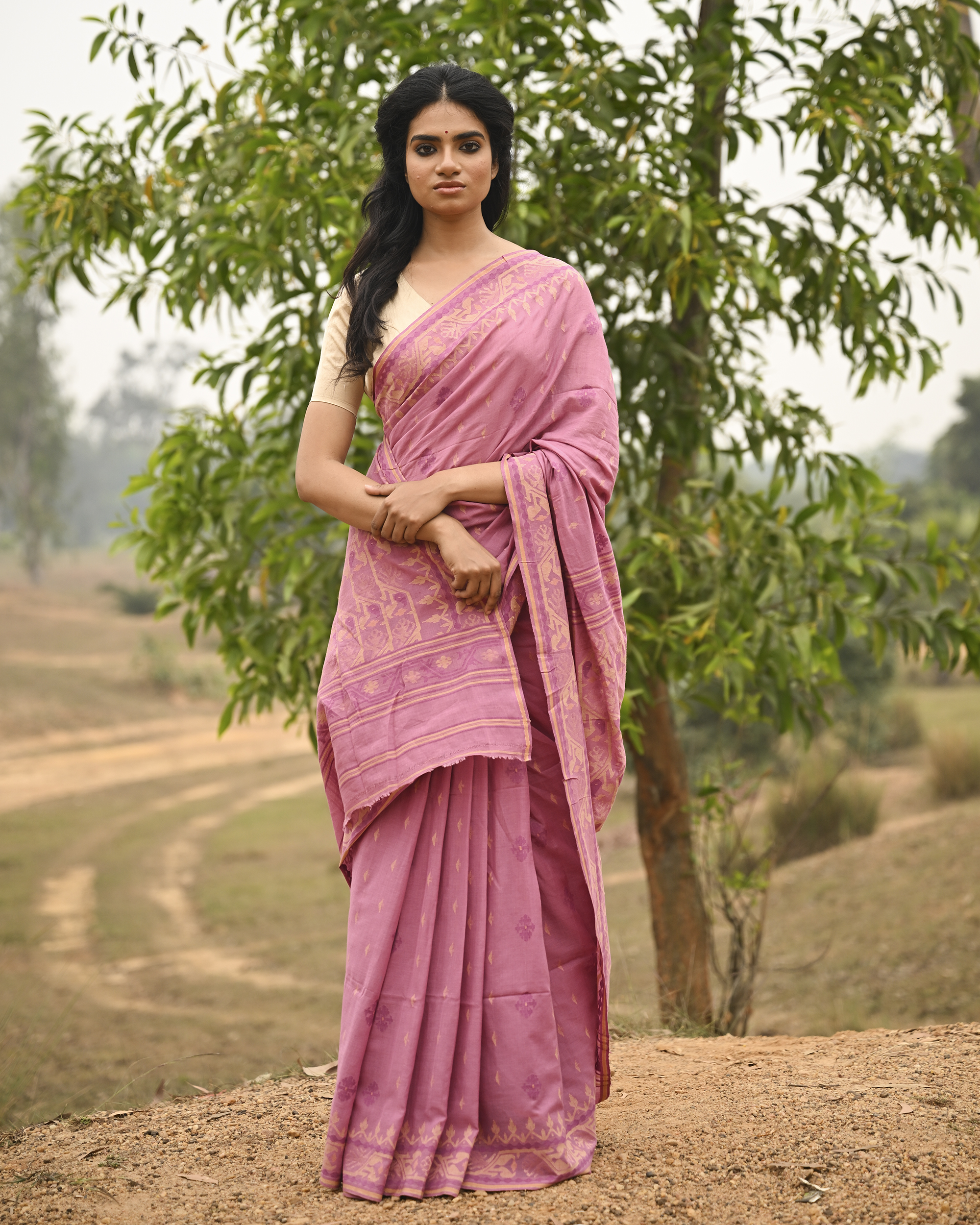 Model wearing the Mauve Gold-Detail Jamdani Saree, a handwoven muted mauve with soft gold detailing Jamdani saree with gentle woven motifs with a graceful festive border and elegant pallu with understated gold-rich work.