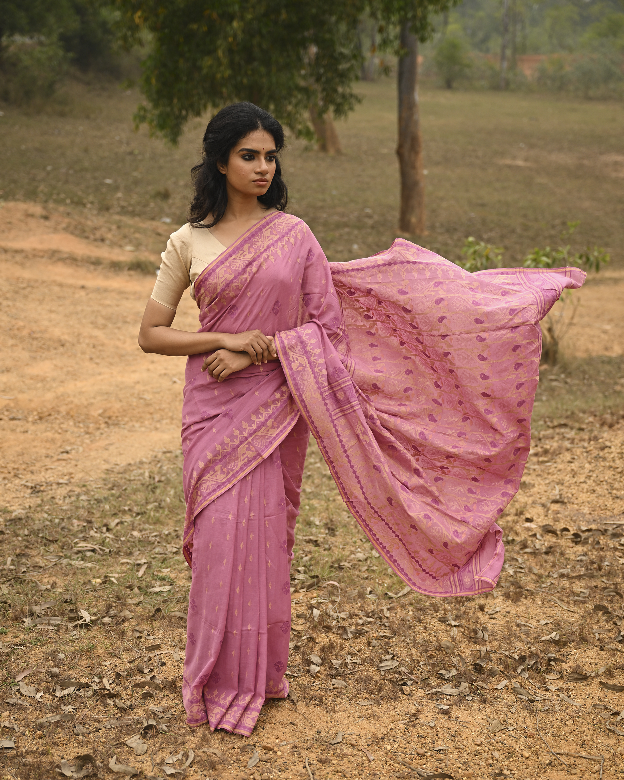 Model wearing the Mauve Gold-Detail Jamdani Saree, a handwoven muted mauve with soft gold detailing Jamdani saree with gentle woven motifs with a graceful festive border and elegant pallu with understated gold-rich work.