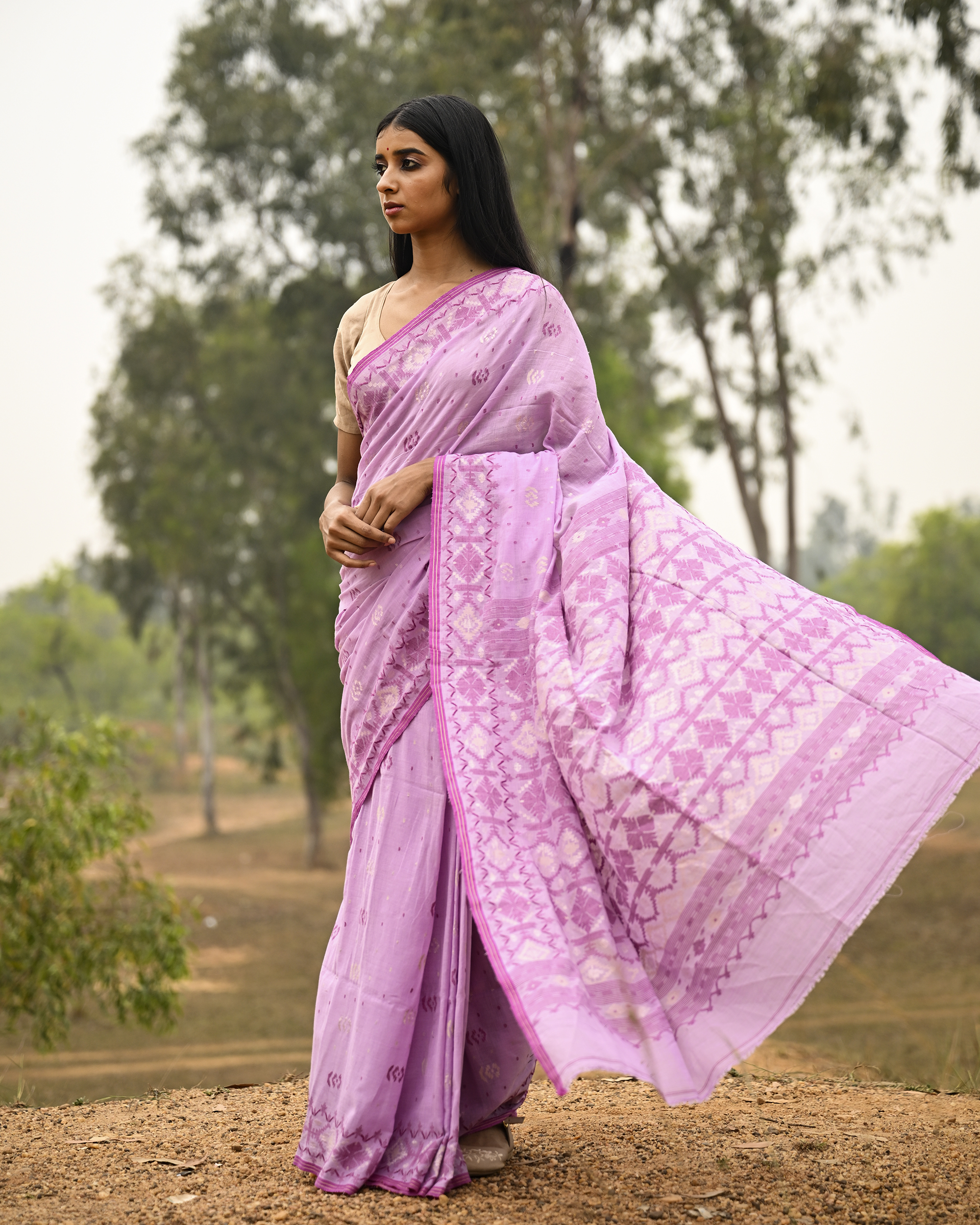 Model wearing the Lilac Silver-Pink Jamdani Saree, a handwoven luminous lilac with silvery-pink weaving Jamdani saree with scattered motifs with a softly ornate weave language and ornate pallu with luminous woven detailing.