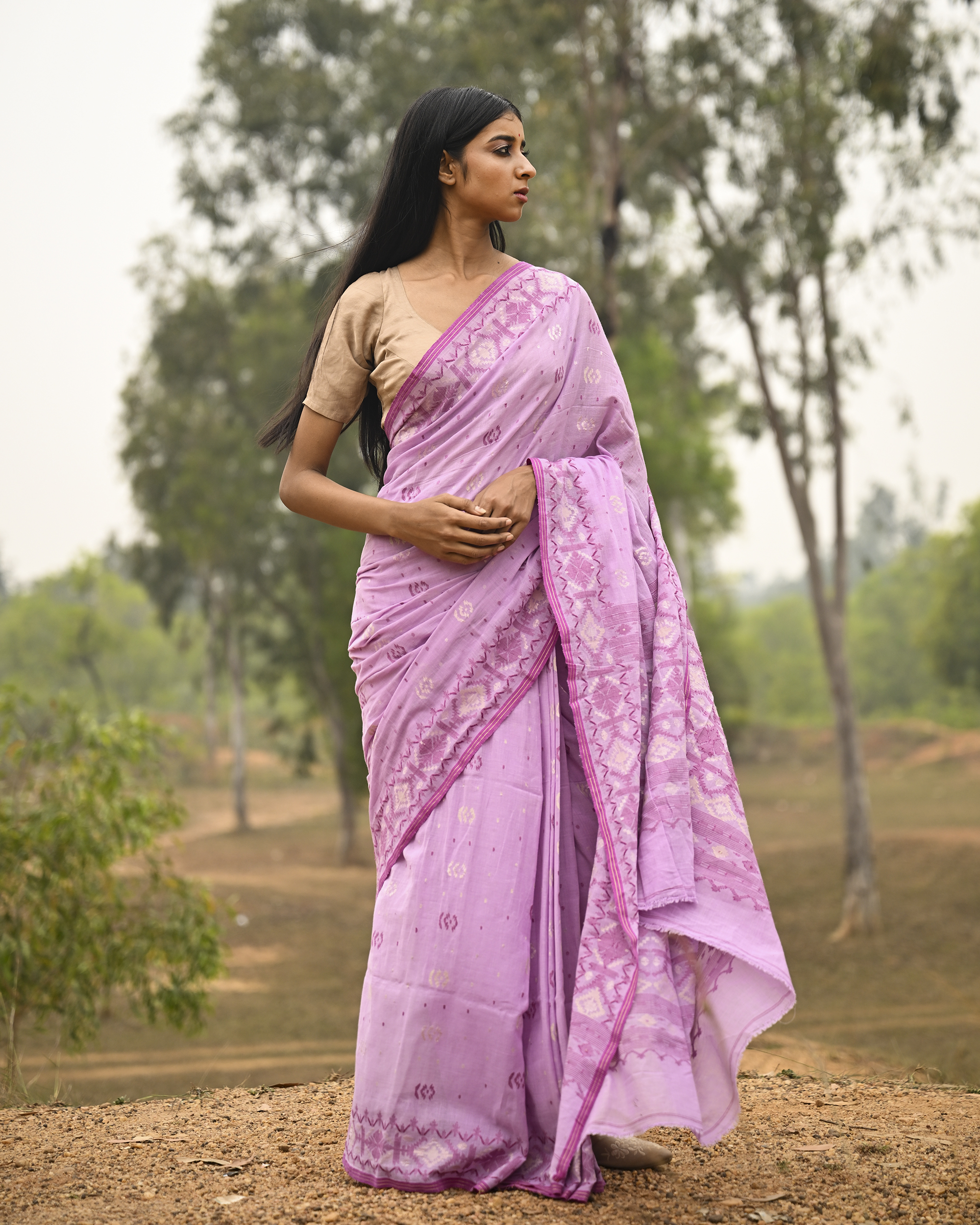 Model wearing the Lilac Silver-Pink Jamdani Saree, a handwoven luminous lilac with silvery-pink weaving Jamdani saree with scattered motifs with a softly ornate weave language and ornate pallu with luminous woven detailing.