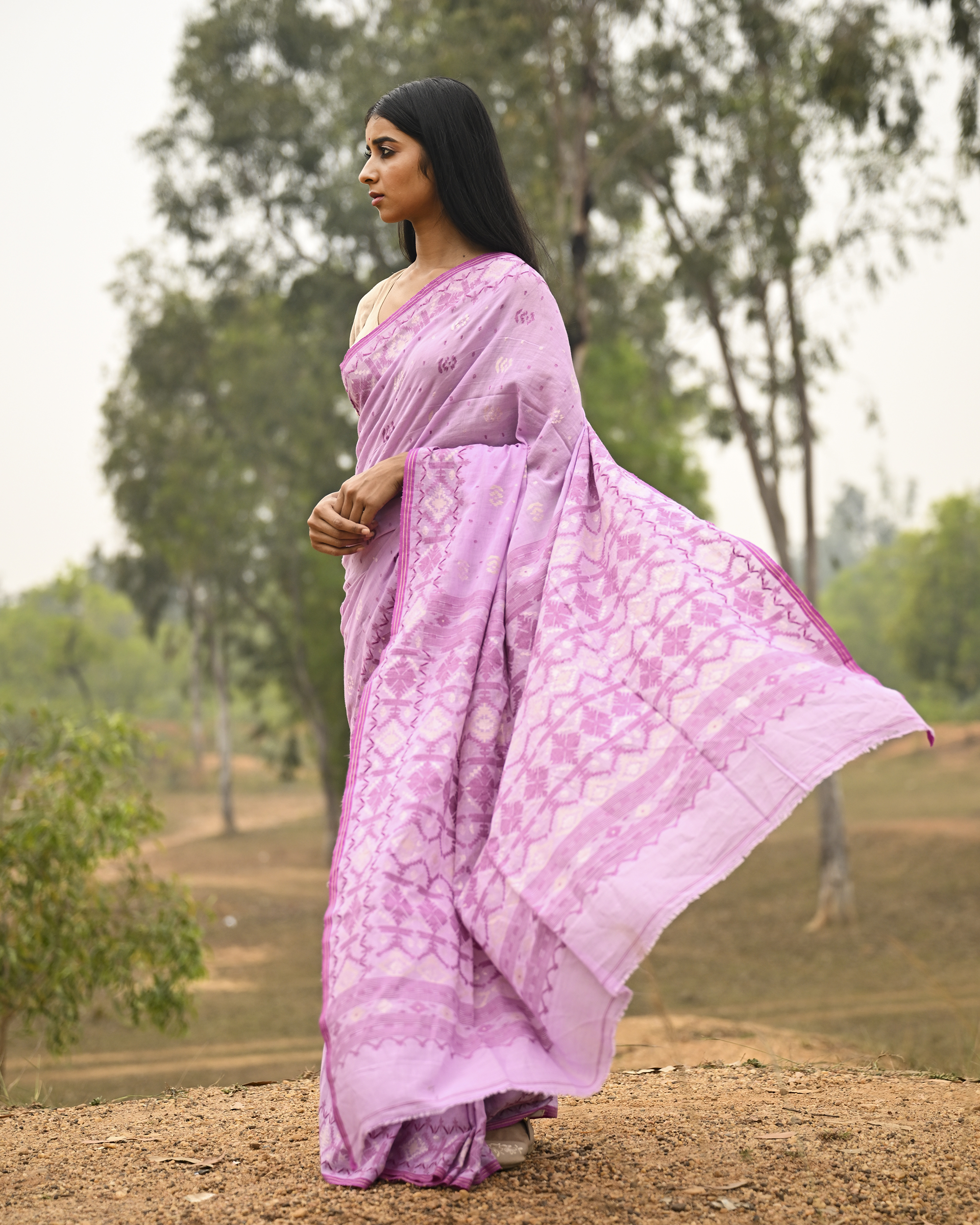 Model wearing the Lilac Silver-Pink Jamdani Saree, a handwoven luminous lilac with silvery-pink weaving Jamdani saree with scattered motifs with a softly ornate weave language and ornate pallu with luminous woven detailing.