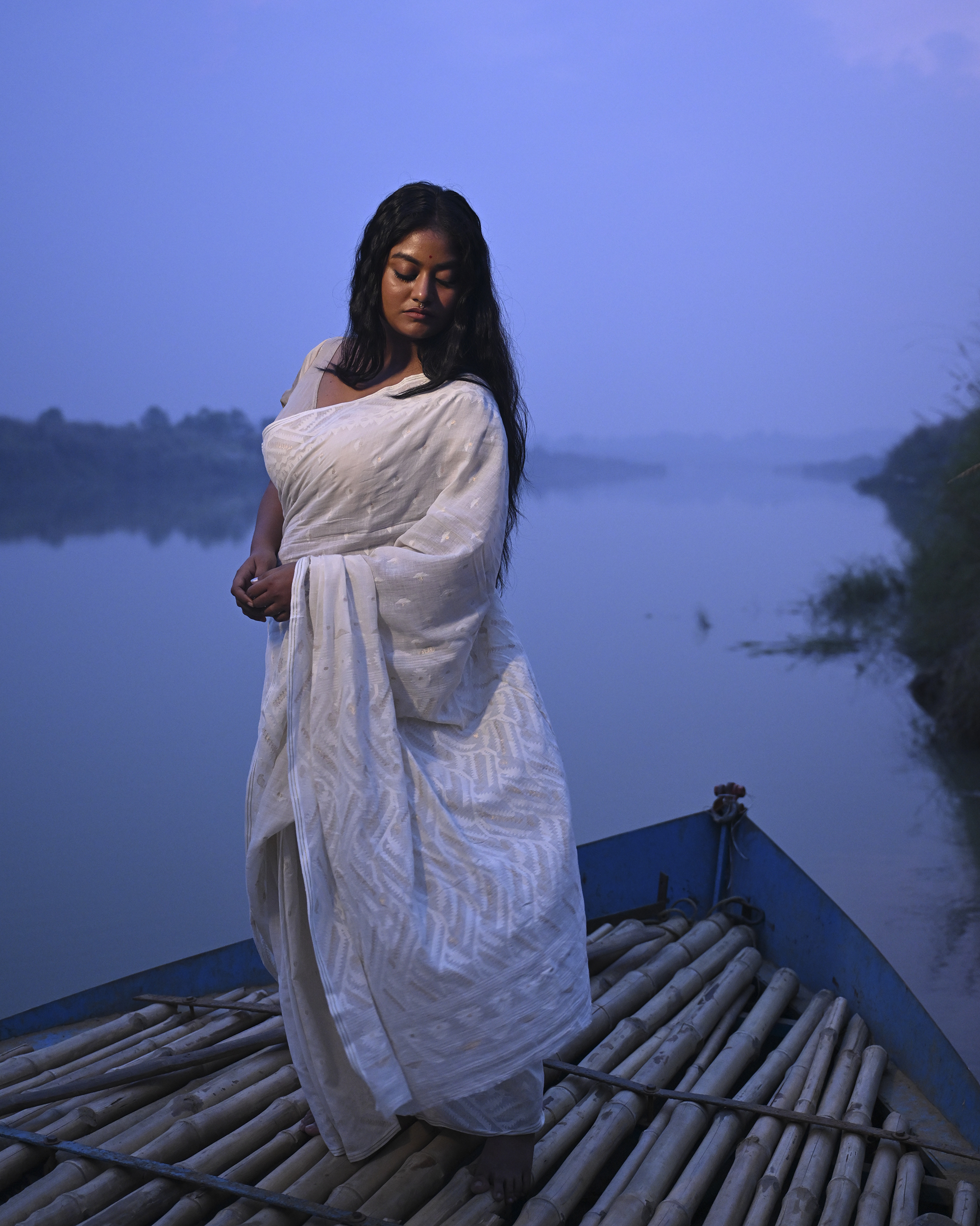 Model wearing the Ivory Whisper Jamdani Saree, a handwoven ivory-white with minimal tonal motifs Jamdani saree with whisper-soft woven motifs across a light field and minimal pallu that lets the texture lead.