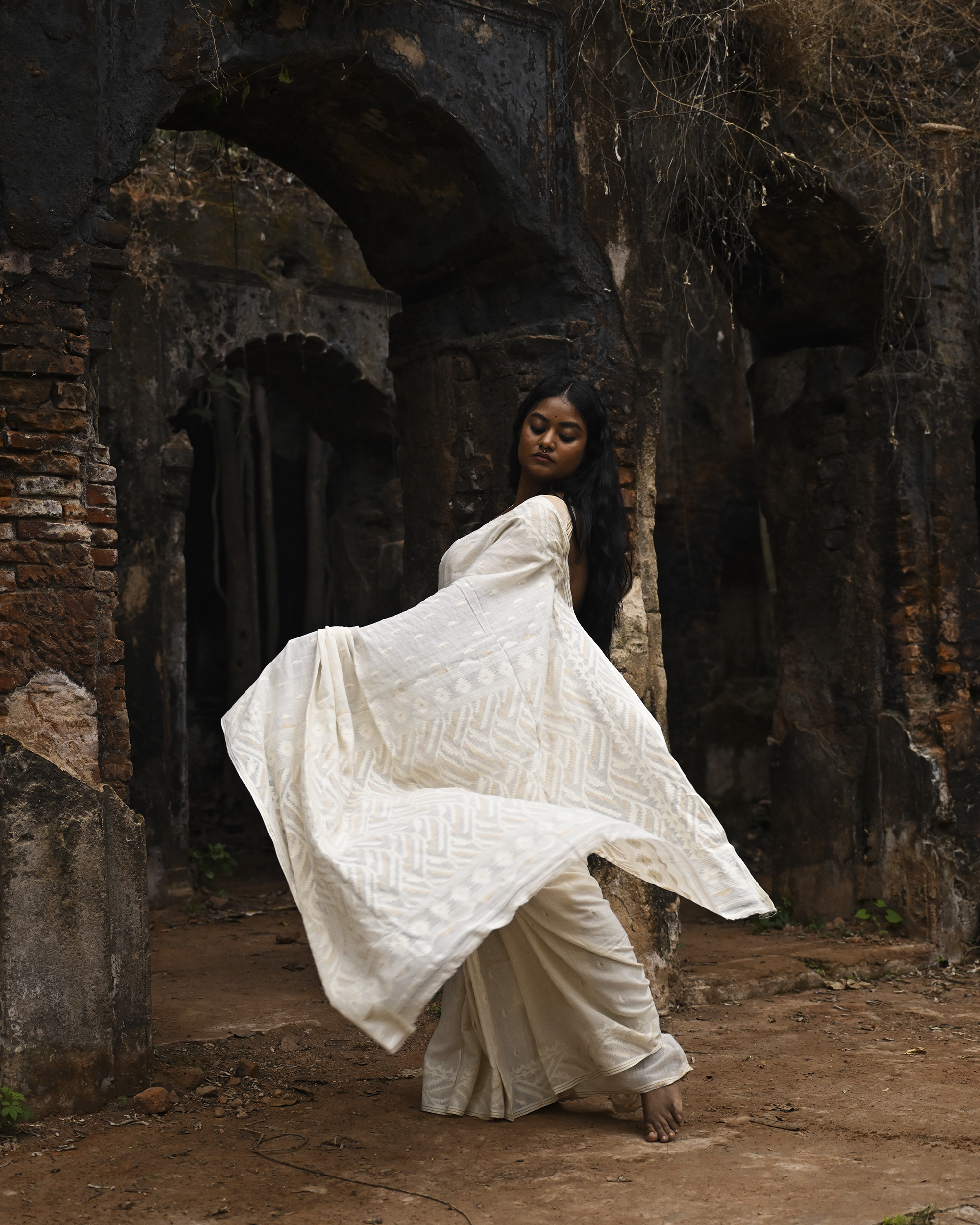 Model wearing the Ivory Whisper Jamdani Saree, a handwoven ivory-white with minimal tonal motifs Jamdani saree with whisper-soft woven motifs across a light field and minimal pallu that lets the texture lead.