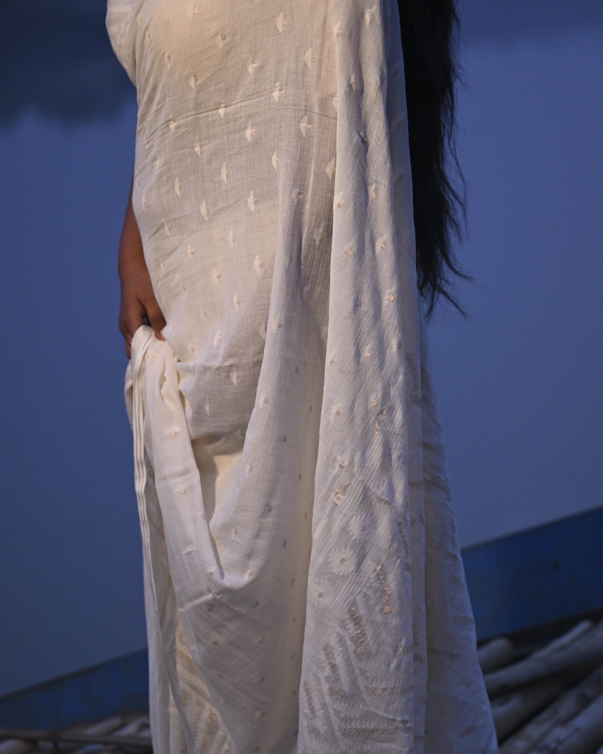 Model wearing the Ivory Whisper Jamdani Saree, a handwoven ivory-white with minimal tonal motifs Jamdani saree with whisper-soft woven motifs across a light field and minimal pallu that lets the texture lead.