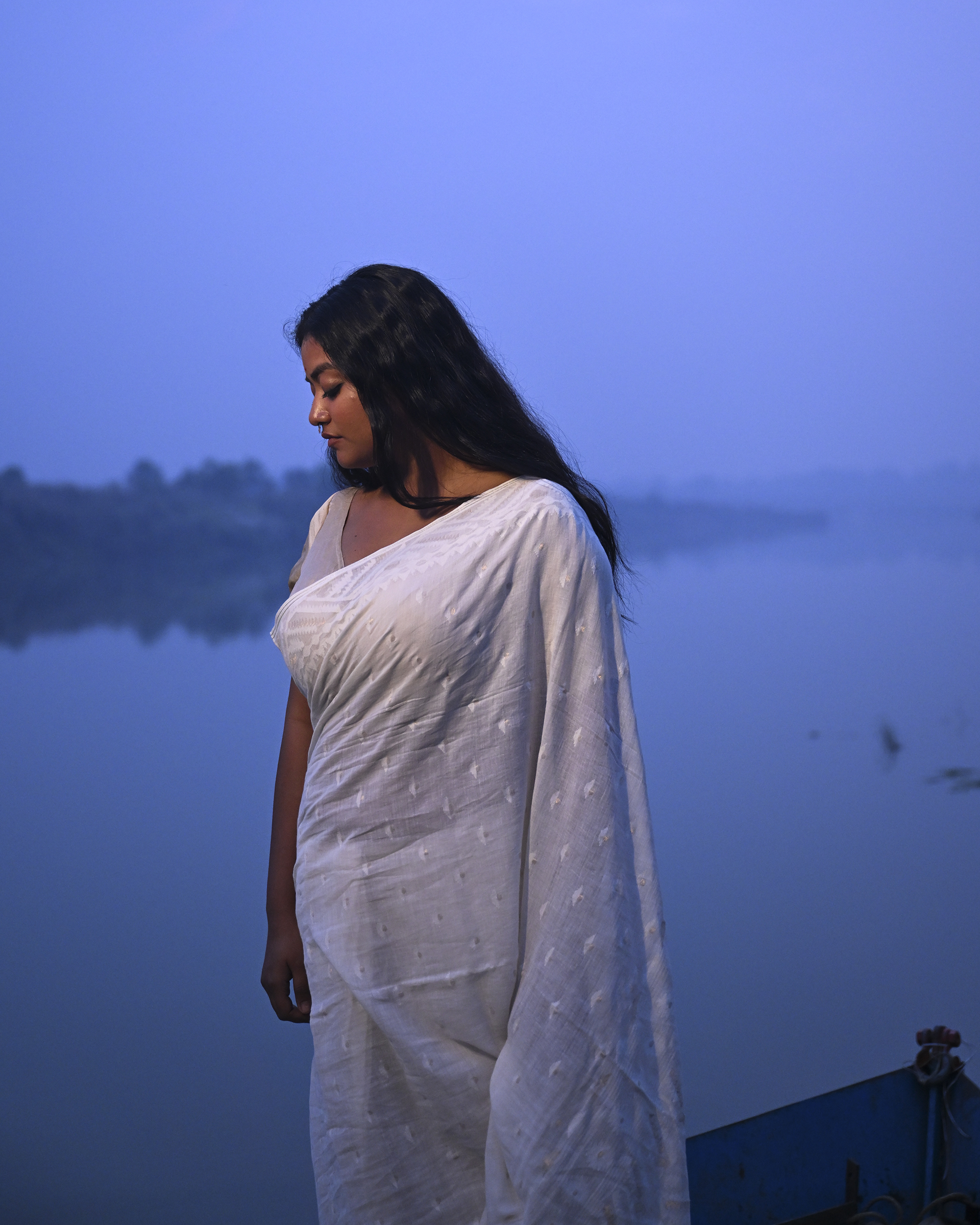 Model wearing the Ivory Whisper Jamdani Saree, a handwoven ivory-white with minimal tonal motifs Jamdani saree with whisper-soft woven motifs across a light field and minimal pallu that lets the texture lead.