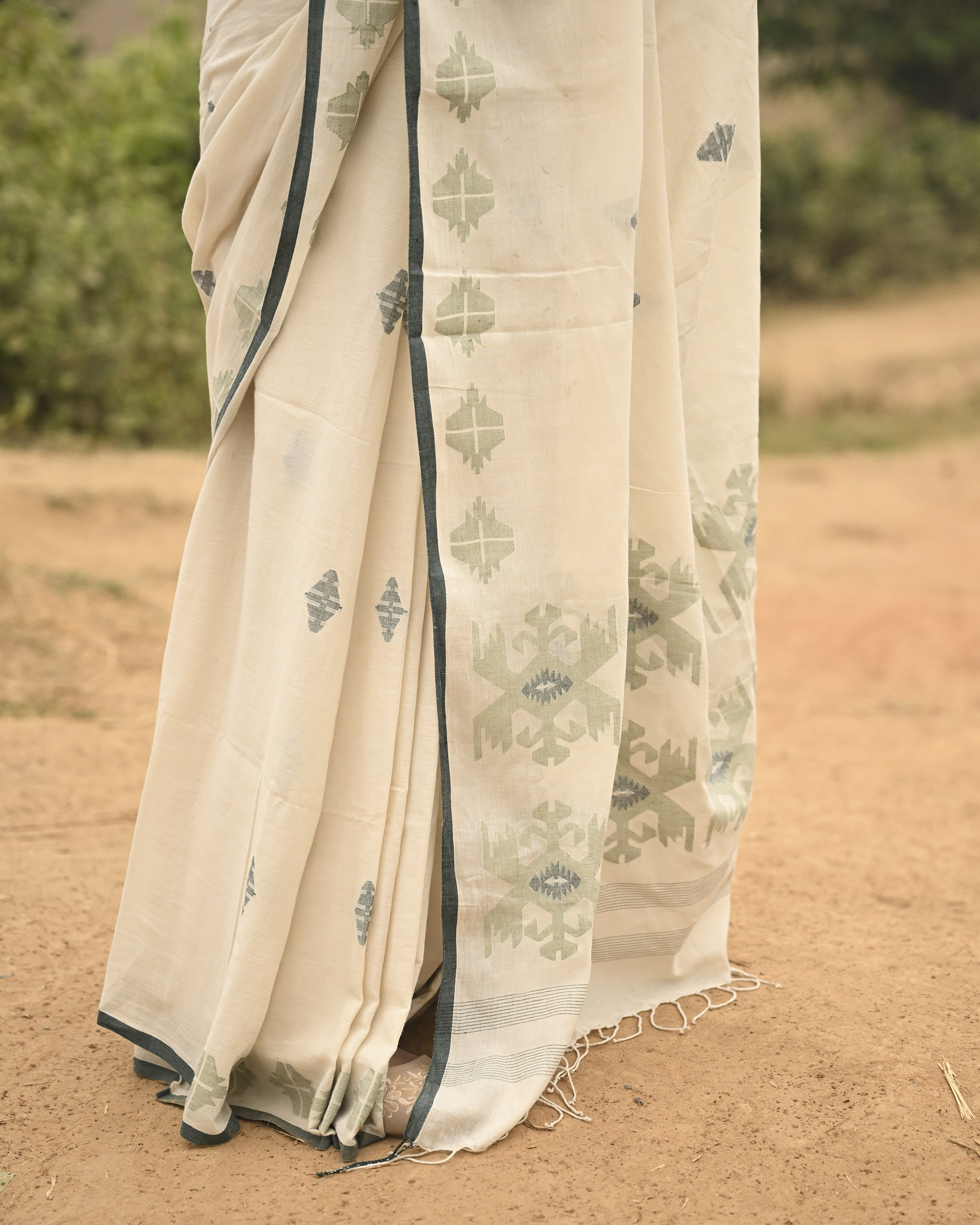Model wearing the Off-White Sage Buti Jamdani Saree, a handwoven off-white with sage-green motifs Jamdani saree with delicate sage butis across a restrained body and delicately worked anchal with soft green highlights.