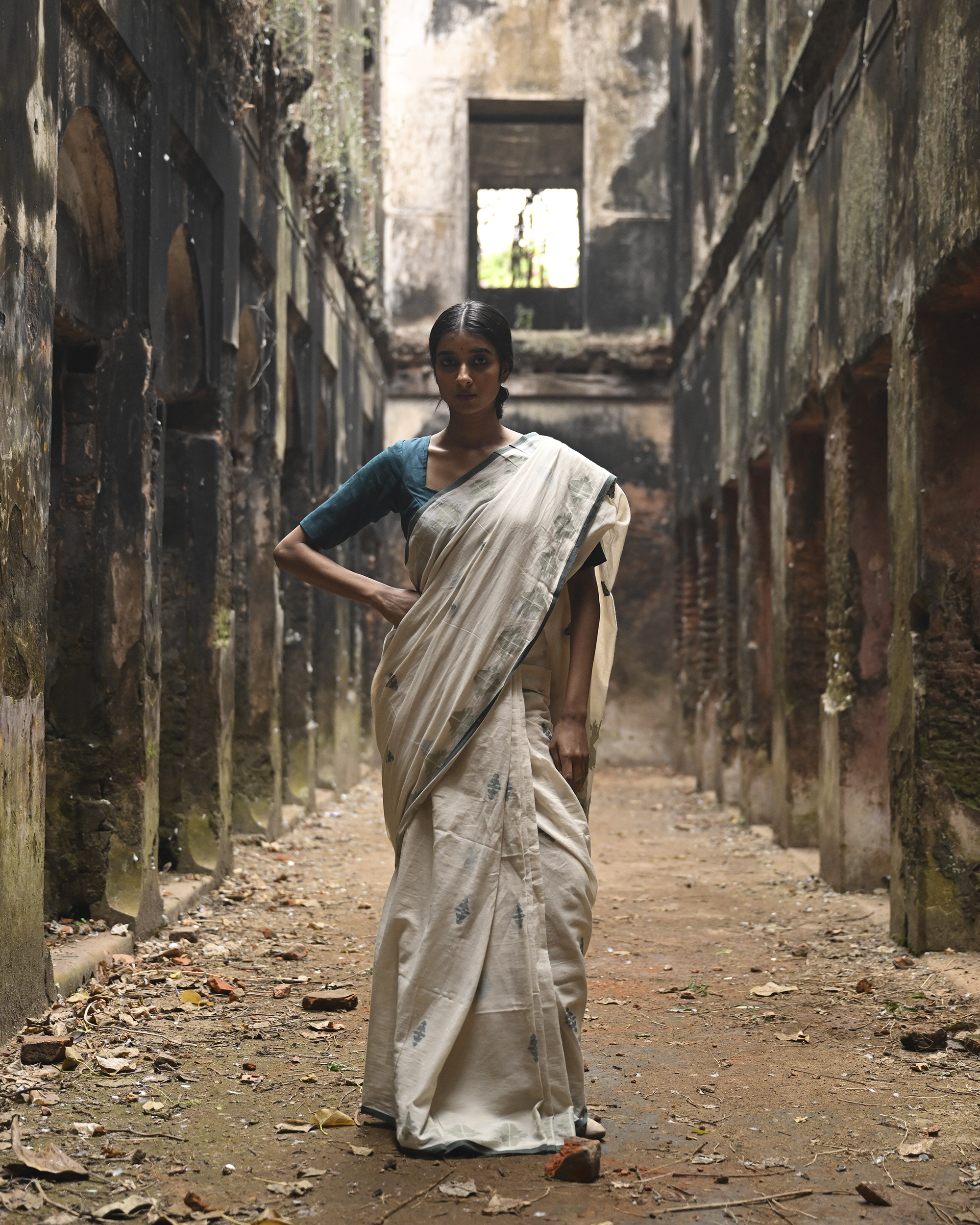 Model wearing the Off-White Sage Buti Jamdani Saree, a handwoven off-white with sage-green motifs Jamdani saree with delicate sage butis across a restrained body and delicately worked anchal with soft green highlights.