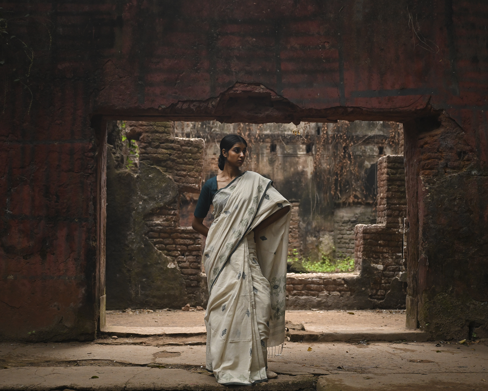 Model wearing the Off-White Sage Buti Jamdani Saree, a handwoven off-white with sage-green motifs Jamdani saree with delicate sage butis across a restrained body and delicately worked anchal with soft green highlights.